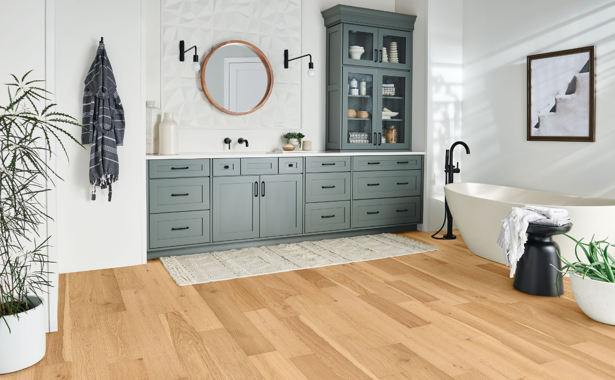 Engineered light hardwood in bathroom with standup tub.